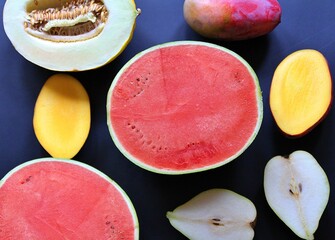 Wall Mural - halved fruit, juicy fruit, red watermelon, ripe mango, two halves of a pear, fresh vitamins, colorful fruit, light yellow melon