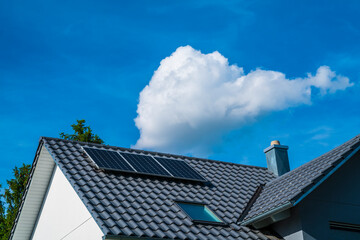 Several solar panels on roof of a house generating clean electrical energy for the building and energy network to save the environment