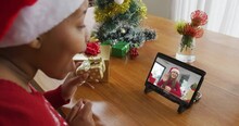 African American Woman With Santa Hat Using Tablet For Christmas Video Call With Woman On Screen