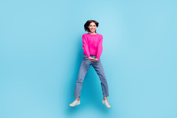 Wall Mural - Full length body size view of attractive cheerful girl jumping having fun isolated over bright blue color background