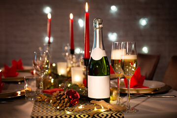 Wall Mural - champagne bottle on a christmas holiday festive party table with wine glass on a red and gold shiny decoration