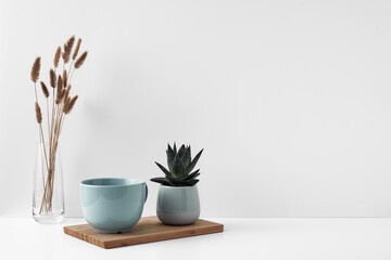 Wall Mural - Mug on a wooden stand, house plant, vase. Eco-friendly materials in the decor of the room, minimalism. Copy space, mock up.