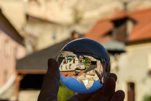Hand Holding Glass Sphere In Front Of Church