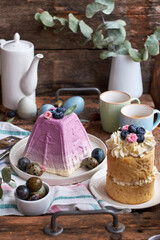 Canvas Print - Traditional Easter Orthodox curd cake with blueberry and Easter cake with cream, blueberries.  Flowers, blueberry, eggs. Wooden background, side view		
