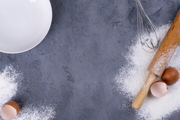 flour and wooden rolling pin on a gray concrete stone table