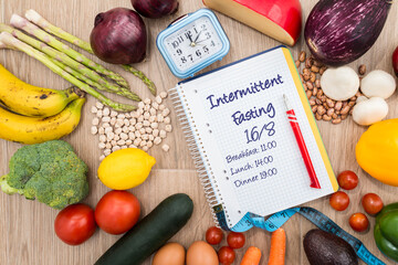 Healthy food around a notebook and a clock with a wooden background.