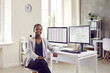 © Studio Romantic - Portrait of happy manager who is responsible for working schedule sitting at desk in corporate company office. Beautiful short haired black woman using data lists and calendars on multiple computers