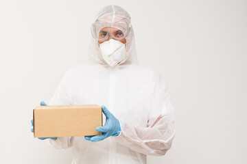 Wall Mural - A man wears protective gear including face mask, gloves and protective suit holding a box