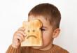 Children and gluten. Preschool boy with toasted bread, with sad emoji. Gluten intolerance by kids.