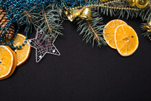 Blue Beads, Pine Cones, Sliced ​​orange, Fir Branches, Golden Bells And A Star On A Black Background