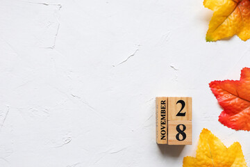 November 28th, Cube wooden calendar showing date on 28 November, Wooden calendar with date on the table.