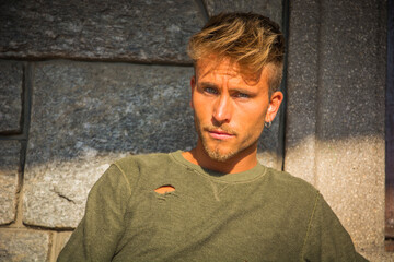 Wall Mural - Handsome young man against stone wall outside