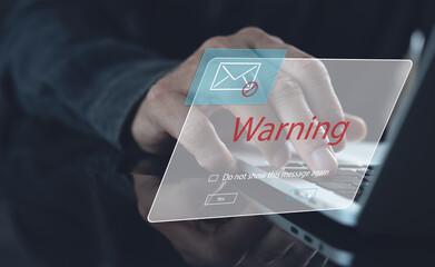 Blocking spam e-mail, warning pop-up for phishing mail, network security concept. Business man working on laptop computer at home with warning window