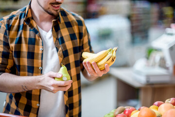 Wall Mural - Young handsome man in a supermarket grocery shopping