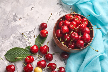Wall Mural - Ripe red and yellow cherries in bowl on gray background