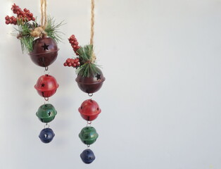 Wall Mural - Two Strands of Purple Green Red Jingle Bells on White Background with Room for Text