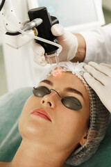 Doctor dermatologist and woman client during laser skin resurfacing treatment