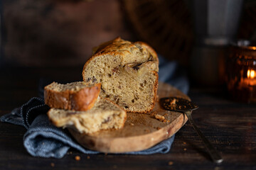 Fresh home made banana bread or butter sponge cake on rustic dark wooden table, organic country still life dessert image. Close up view with copy space. 