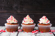 Christmas peppermint cupcakes with creamy frosting. Row against a rustic wood background.