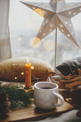 Wall Mural - Christmas star, cup of tea, lights, trees, candle at window. Scandi Winter hygge. Merry Xmas