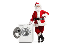 Full Length Portrait Of Santa Claus Leaning On An Open Washing Machine And Pointing
