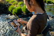 A close up of an asian female selecting fly fishing flies from a box