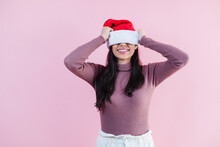 Portrait Of Young Latin Woman With Copy Space In A Christmas Concept On Pink Background	
