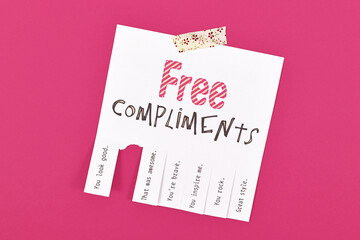 Tear off note with motivational free compliments on pink background