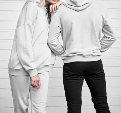 Close up of hoodie on a girl. Pair of woman and man are standing in hooded jumper. Branding and design mockup template. Close up of textile fabric
