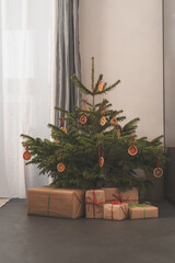 Wall Mural - Small christmas tree with natural decorations and gift boxes