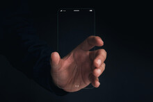 Futuristic Transparent Glass Phone Technology. Super Slim Transparent Future Smartphone With Vertical Mock-up Blank Screen In Hand On Dark Background.