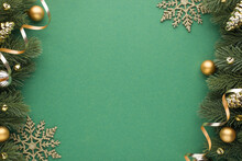 Top View Photo Of Gold And Silver Christmas Tree Balls Toys Cones Small Bells Snowflakes And Serpentine On Pine Branches On Isolated Green Background With Empty Space