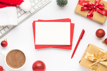 Wall Mural - Top view photo of keyboard cup of hot drinking santa claus hat pine toy red christmas tree balls gift boxes stack of red envelopes paper sheet and pen on isolated white background with copyspace