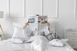 © Pixel-Shot - Morning of young woman reading newspaper in bed