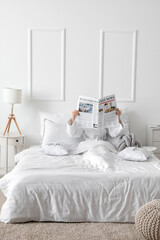 Poster - Morning of young woman reading newspaper in bed