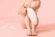 Beautiful young woman with soft feathers on color background. Epilation concept