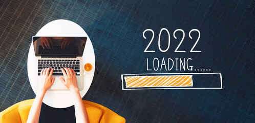 Wall Mural - Loading new year 2022 with person using a laptop on a white table