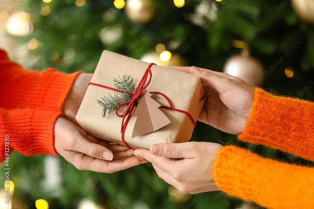 Women with present at home on Christmas eve, closeup