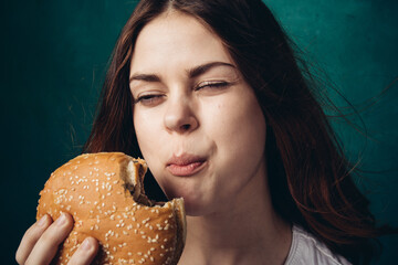 Wall Mural - woman eating hamburger fast food snack close-up