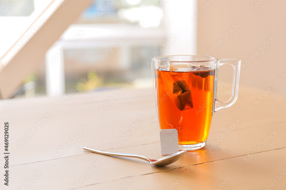 Glass cup of hot tea on table in cafe