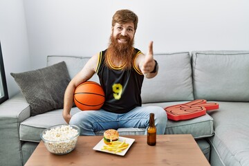 Sticker - Caucasian man with long beard holding basketball ball cheering tv game smiling friendly offering handshake as greeting and welcoming. successful business.