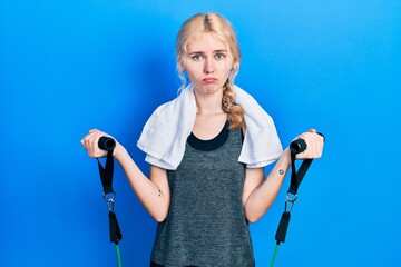 Poster - Beautiful caucasian sports woman with blond hair training arm resistance with elastic arm bands depressed and worry for distress, crying angry and afraid. sad expression.