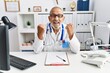 © Krakenimages.com - Mature doctor man at the clinic celebrating surprised and amazed for success with arms raised and open eyes. winner concept.