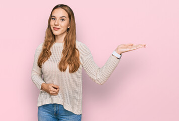 Canvas Print - Young blonde woman wearing casual clothes smiling cheerful presenting and pointing with palm of hand looking at the camera.