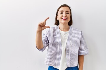 Sticker - Beautiful middle age hispanic woman standing over isolated background covering one eye with hand, confident smile on face and surprise emotion.