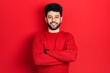 © Krakenimages.com - Young arab man with beard wearing casual red sweater happy face smiling with crossed arms looking at the camera. positive person.