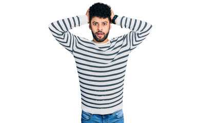 Sticker - Young arab man with beard wearing casual striped sweater crazy and scared with hands on head, afraid and surprised of shock with open mouth