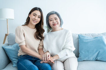 Portrait of Asian lovely family, young daughter hugging older mother. 