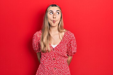 Poster - Beautiful hispanic woman wearing summer dress making fish face with lips, crazy and comical gesture. funny expression.