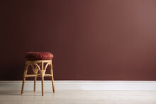 Stylish Wooden Stool With Cushion Near Color Wall, Space For Text. Interior Element
